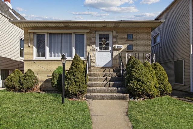 view of exterior entry with a lawn