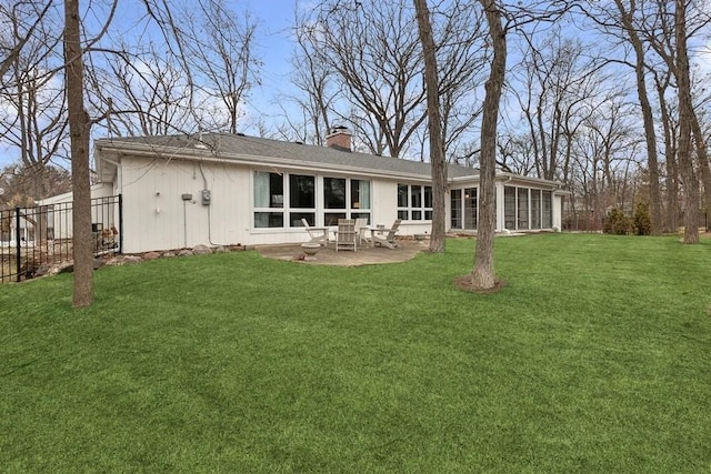 rear view of property with a patio, a sunroom, and a yard