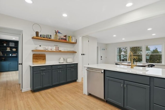 kitchen featuring gray cabinetry, sink, stainless steel dishwasher, and light hardwood / wood-style floors