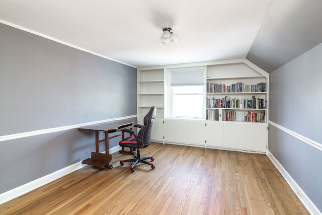 office featuring lofted ceiling and light hardwood / wood-style flooring