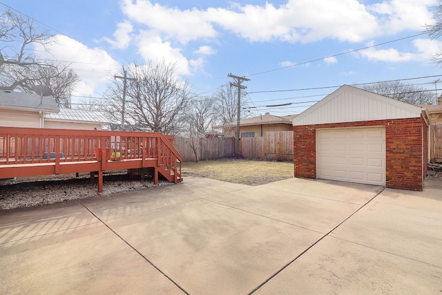 view of patio featuring a wooden deck, a garage, and an outbuilding