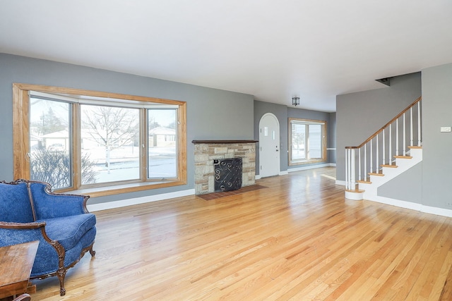 living room with a fireplace and light wood-type flooring