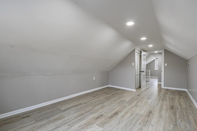 additional living space with lofted ceiling and light hardwood / wood-style flooring