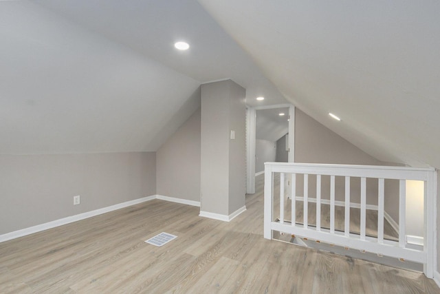 bonus room with lofted ceiling and light hardwood / wood-style flooring