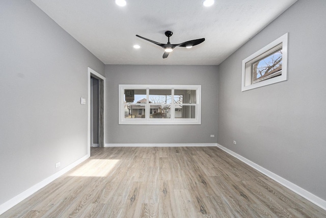 spare room with ceiling fan, a healthy amount of sunlight, and light wood-type flooring