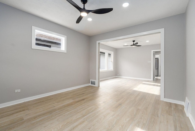 empty room featuring ceiling fan and light hardwood / wood-style flooring