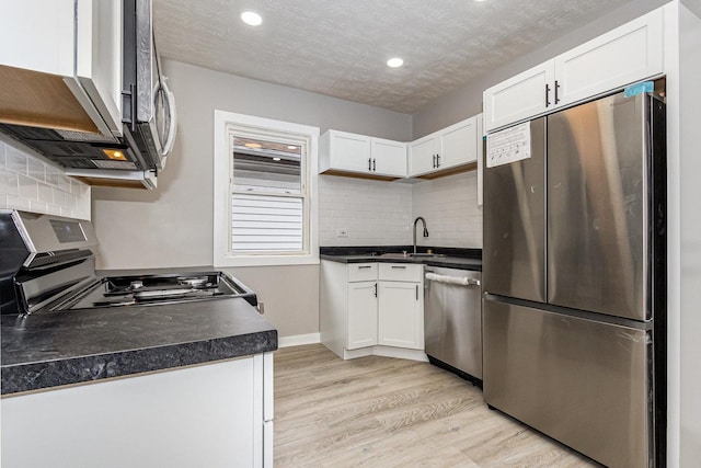 kitchen featuring appliances with stainless steel finishes, white cabinets, and light hardwood / wood-style floors