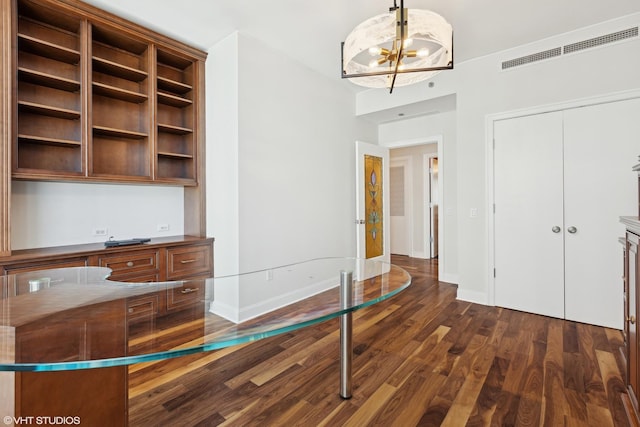 interior space with baseboards, dark wood-type flooring, visible vents, and an inviting chandelier