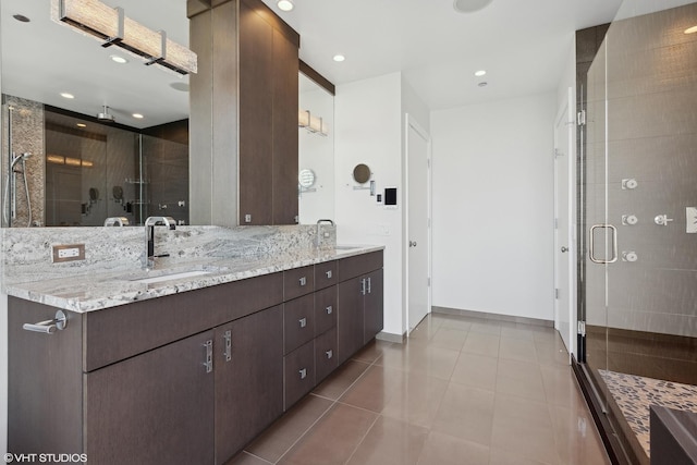 full bathroom with double vanity, tile patterned flooring, a sink, and a shower stall