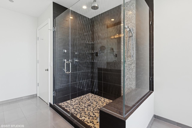 full bath featuring a shower stall, baseboards, and tile patterned floors