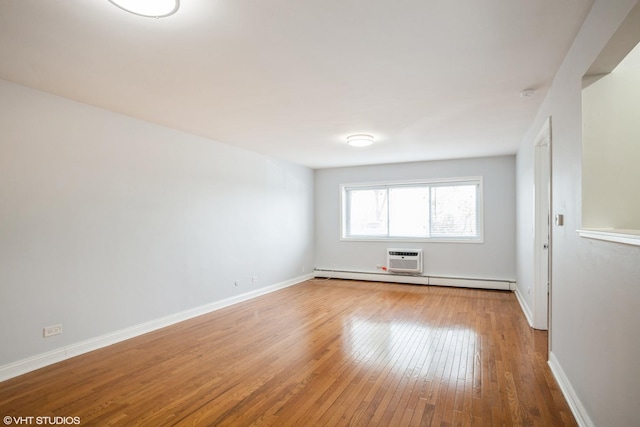 unfurnished room with wood-type flooring and a baseboard heating unit