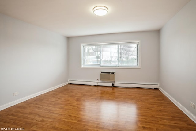 empty room featuring a baseboard heating unit and hardwood / wood-style floors