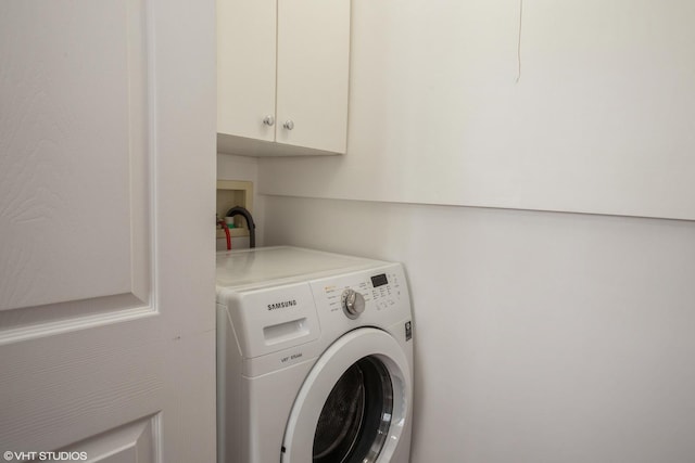 laundry area featuring washer / clothes dryer and cabinets