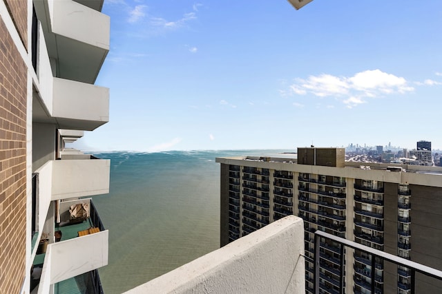 balcony with a water view and a view of city