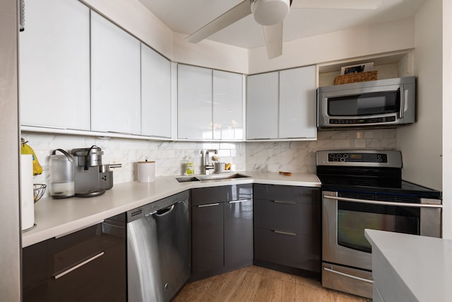 kitchen featuring white cabinetry, appliances with stainless steel finishes, light countertops, and a sink