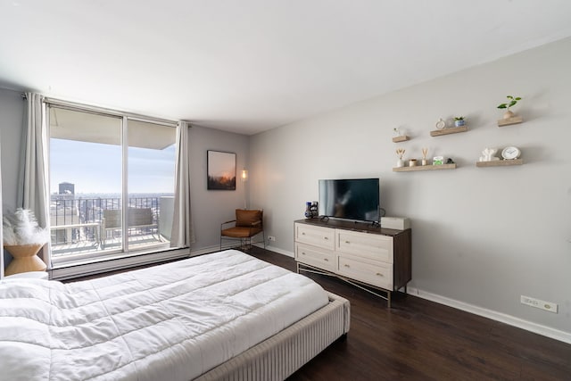 bedroom with a view of city, dark wood-type flooring, access to exterior, and baseboards