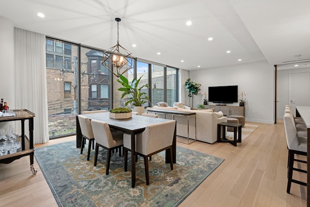 dining room featuring floor to ceiling windows, a chandelier, and light hardwood / wood-style flooring