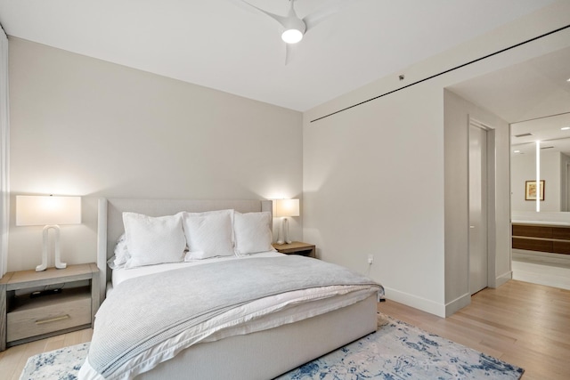 bedroom featuring ceiling fan, ensuite bathroom, and light hardwood / wood-style floors