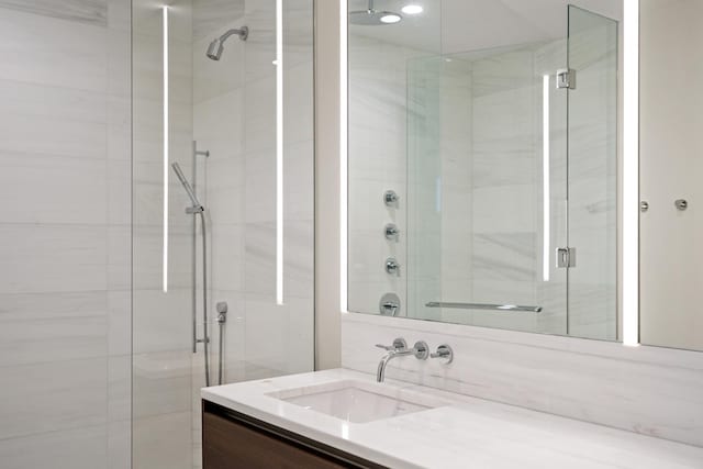 bathroom with vanity and a shower with door