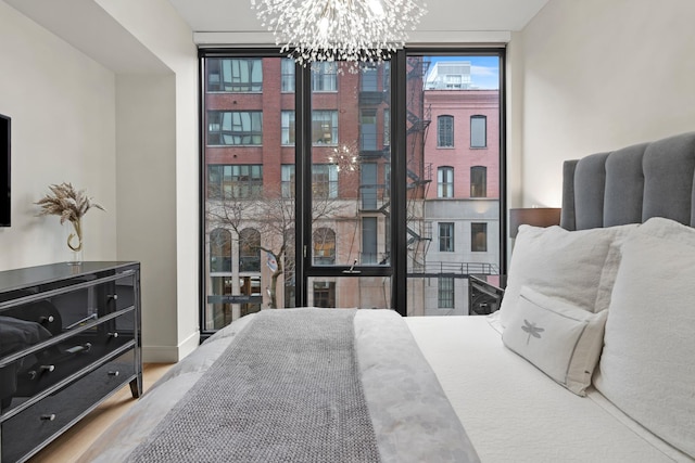 bedroom featuring an inviting chandelier, floor to ceiling windows, and hardwood / wood-style floors