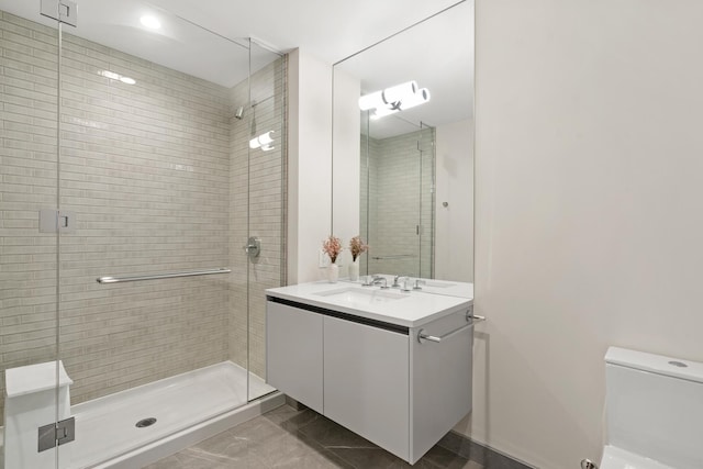 bathroom with vanity, a shower with door, and toilet