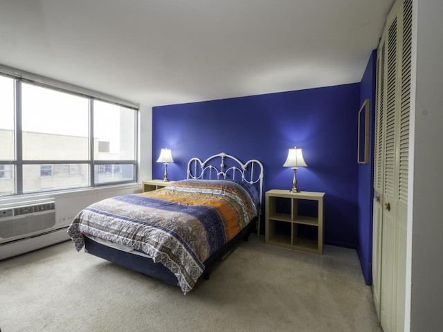 carpeted bedroom with a closet and a wall unit AC