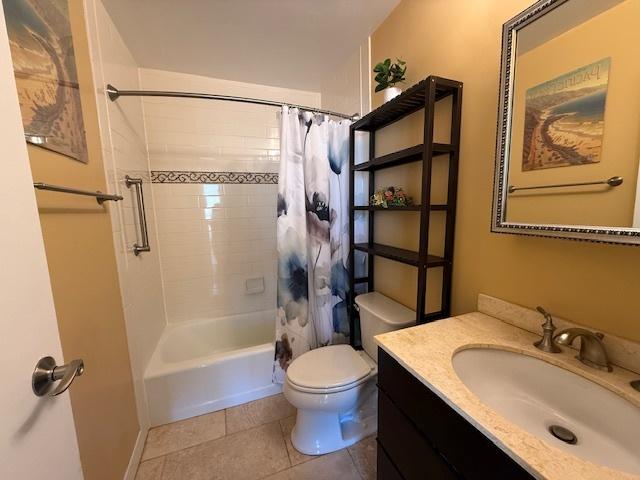 full bath featuring shower / bath combo with shower curtain, vanity, toilet, and tile patterned floors