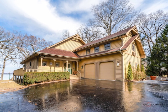 view of front facade featuring a water view, a porch, and a garage