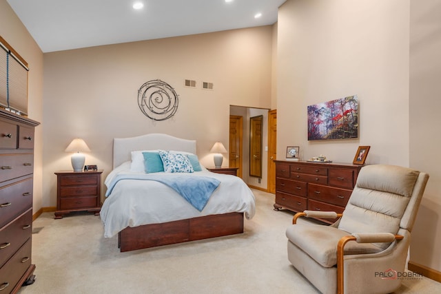 bedroom featuring light colored carpet and high vaulted ceiling