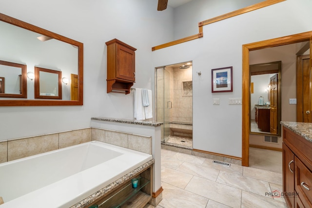 bathroom with tile patterned flooring, vanity, and plus walk in shower