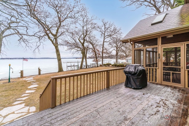 wooden terrace with a grill, a sunroom, and a water view