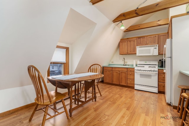 kitchen with sink, vaulted ceiling with beams, white appliances, and light hardwood / wood-style floors