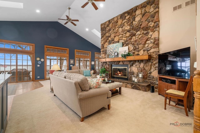 carpeted living room featuring ceiling fan, a fireplace, and high vaulted ceiling