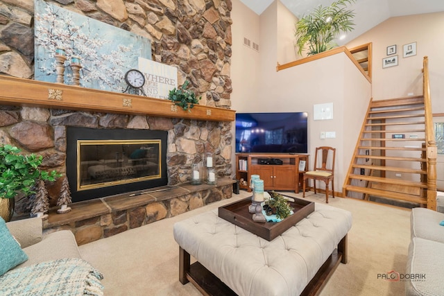 carpeted living room featuring a stone fireplace and high vaulted ceiling