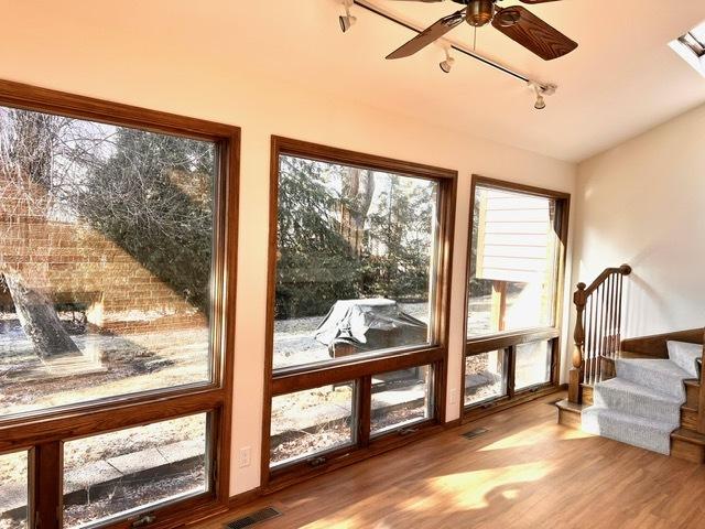 entryway with hardwood / wood-style floors, track lighting, and ceiling fan