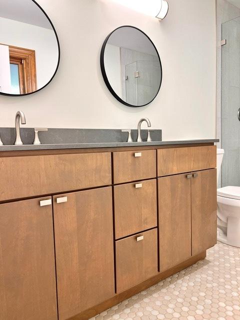 bathroom featuring vanity, a shower, and toilet