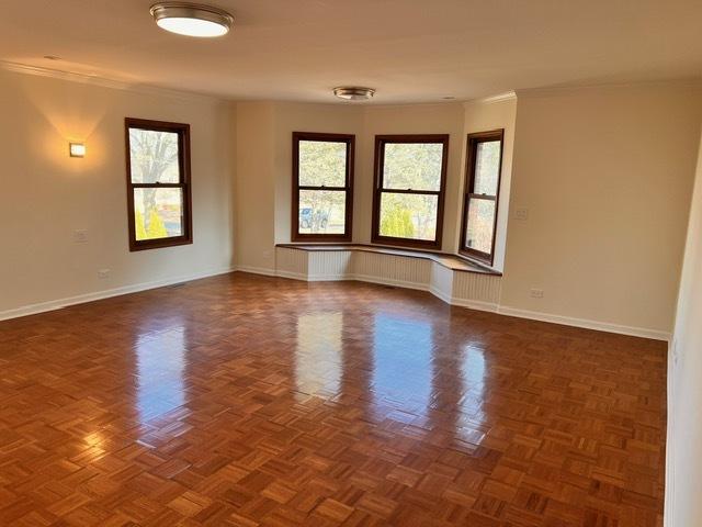 empty room featuring crown molding and dark parquet floors