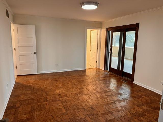 unfurnished room with dark parquet flooring and crown molding