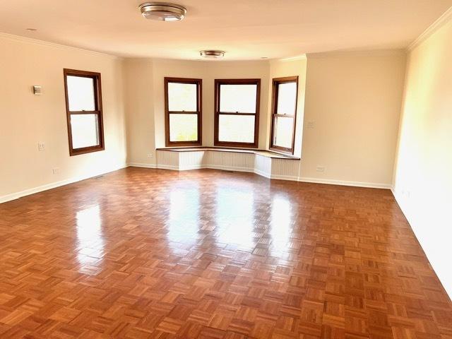 spare room with crown molding and dark parquet flooring