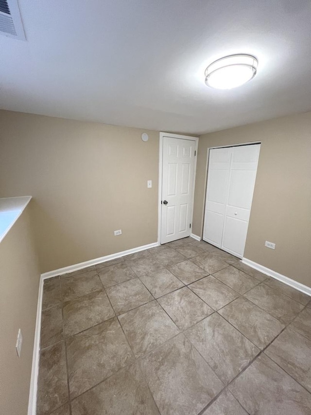 unfurnished bedroom with tile patterned flooring and a closet