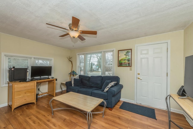 living room with ceiling fan, hardwood / wood-style floors, and a textured ceiling