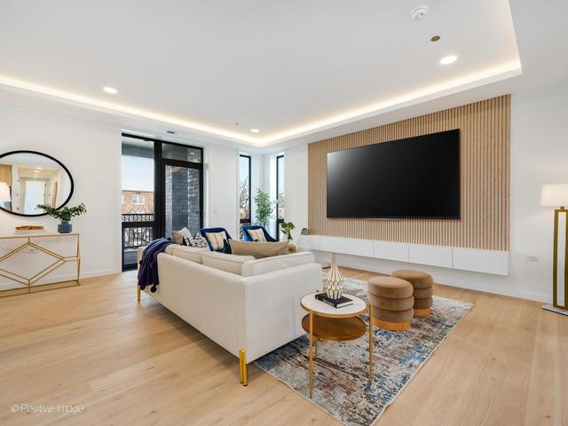 living room featuring a tray ceiling and light hardwood / wood-style flooring