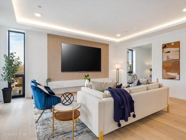 living room featuring a raised ceiling and light hardwood / wood-style floors