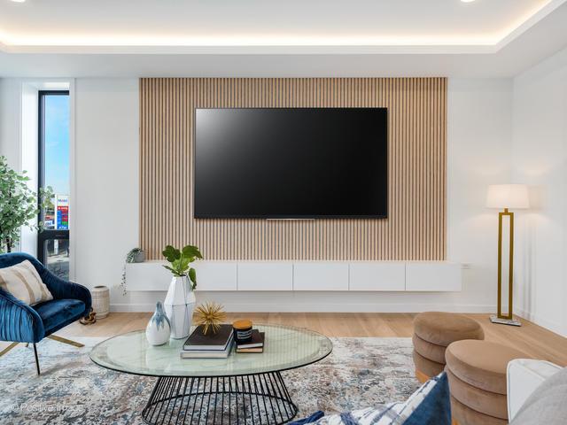 living room with a tray ceiling and light hardwood / wood-style flooring