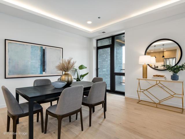 dining area featuring a raised ceiling and light hardwood / wood-style flooring