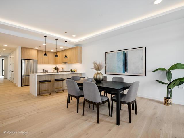 dining room with a raised ceiling and light wood-type flooring