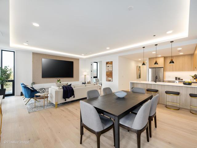 dining room featuring a raised ceiling and light hardwood / wood-style flooring