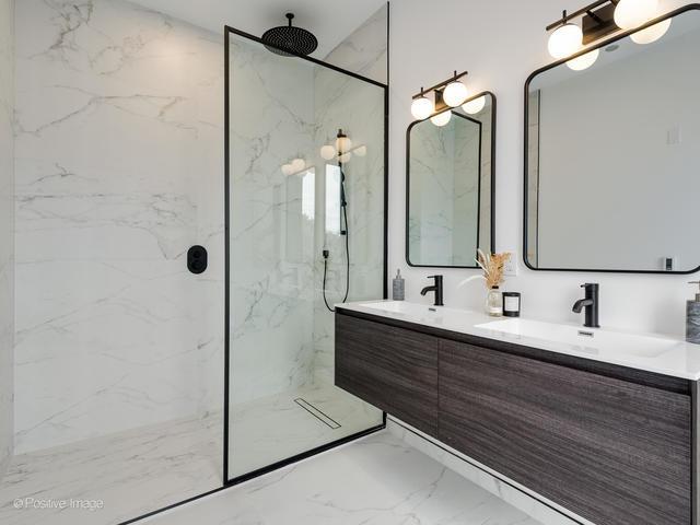 bathroom with vanity and a tile shower