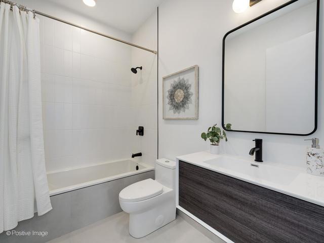 full bathroom featuring vanity, shower / bath combination with curtain, and toilet