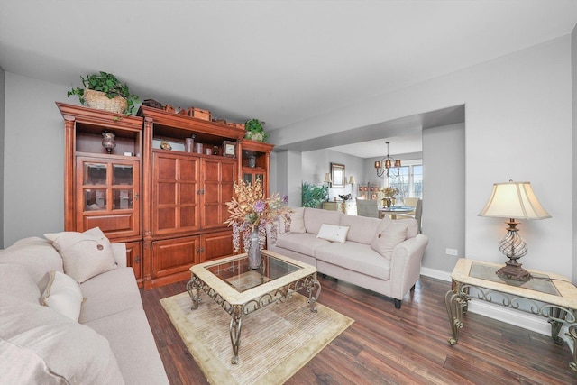 living room featuring a notable chandelier and dark hardwood / wood-style flooring